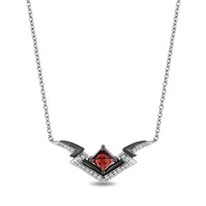 May include: A silver necklace with a geometric pendant featuring a square, red gemstone at the center. The pendant has black and white accents, with small white stones. The chain is a delicate silver.