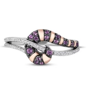 May include: A silver ring with a unique design. The ring features a curved band with a row of small, round, purple gemstones and rose gold accents. The band is also adorned with small, clear gemstones.