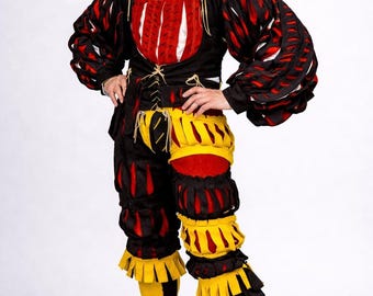 May include: A multi-colored doublet and breeches set featuring black, red, and yellow fabric panels with slashed detailing. The outfit includes a white ruffled collar, long puffed sleeves, and yellow stockings paired with red leather shoes.