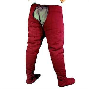 Back view of dark red quilted leg protection showing the rear openings and vertical quilting lines.