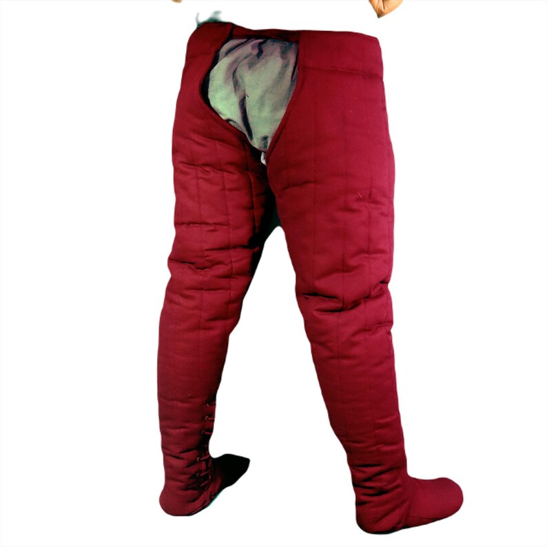 Back view of dark red quilted leg protection showing the rear openings and vertical quilting lines.