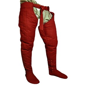 Close-up of dark red quilted leg wrap showing the buckled waistband and side strap details.