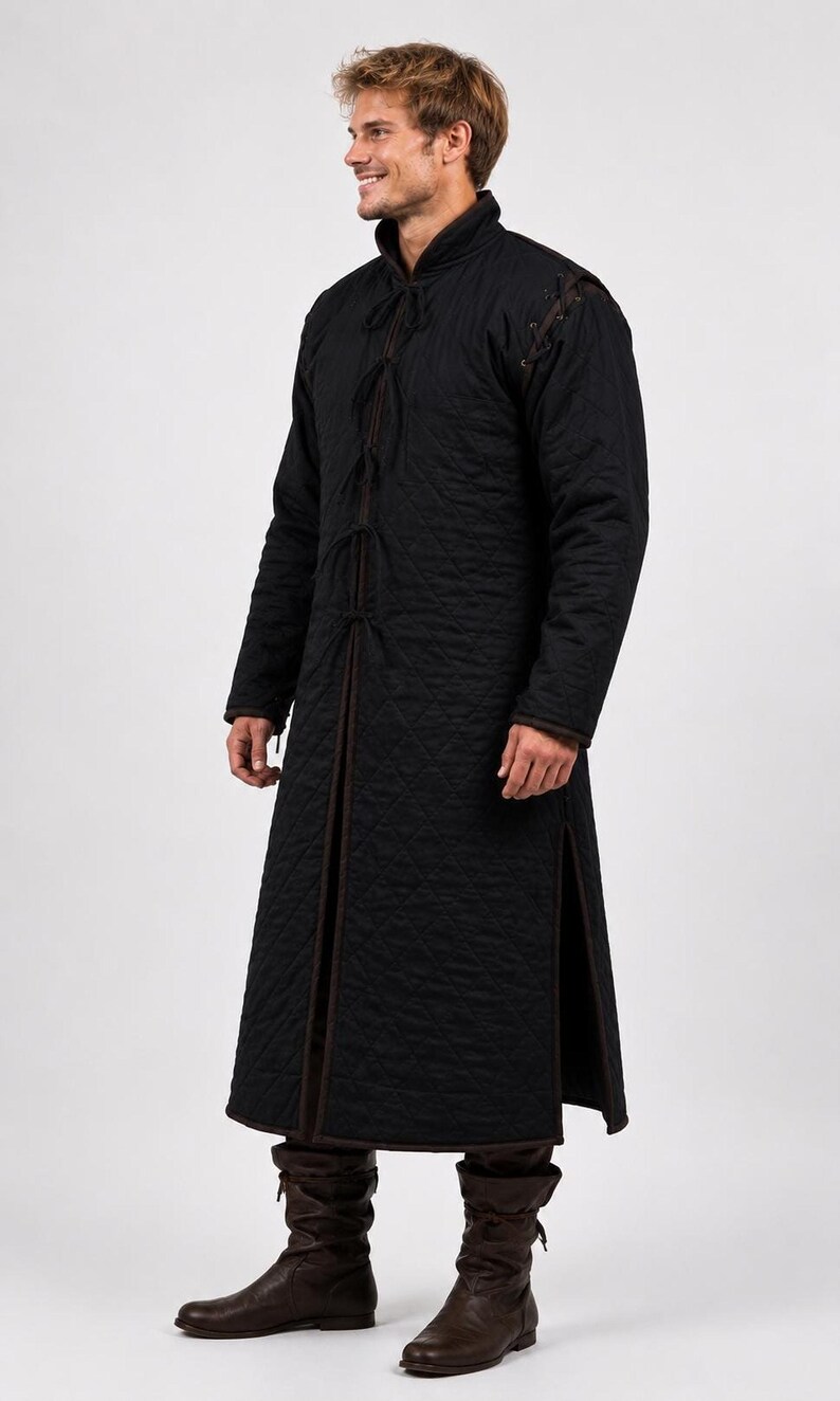 A man wearing a black quilted long gambeson coat shown in profile against a white backdrop.
