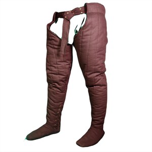 Angled front view of brown quilted medieval leg wrappings with side lacing on the lower legs.