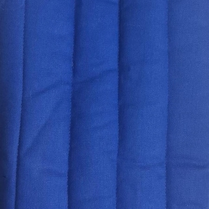 A close-up shot of solid blue fabric with vertical quilted stitching lines running down the length.