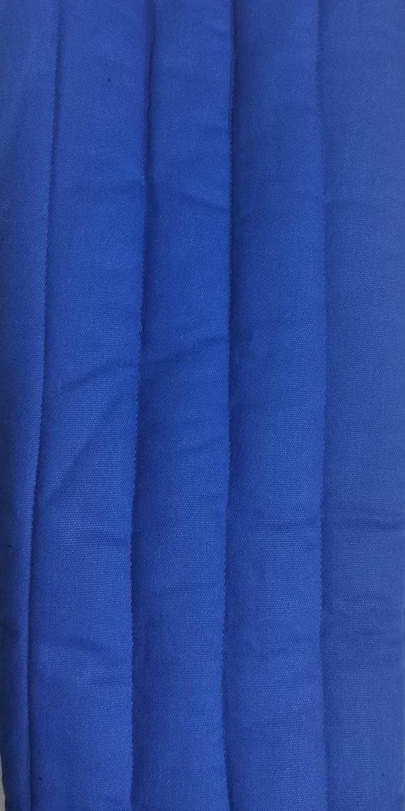 A close-up shot of solid blue fabric with vertical quilted stitching lines running down the length.