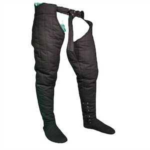 Front view of black quilted medieval leg wrappings with a buckled belt and integrated foot covers.
