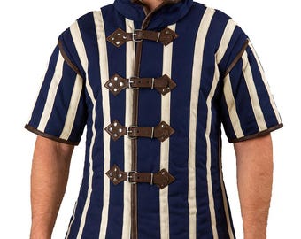 May include: A navy blue and cream striped medieval gambeson with short sleeves. The padded garment features brown leather straps and trim, and a high collar. The front is secured with three leather straps and buckles.