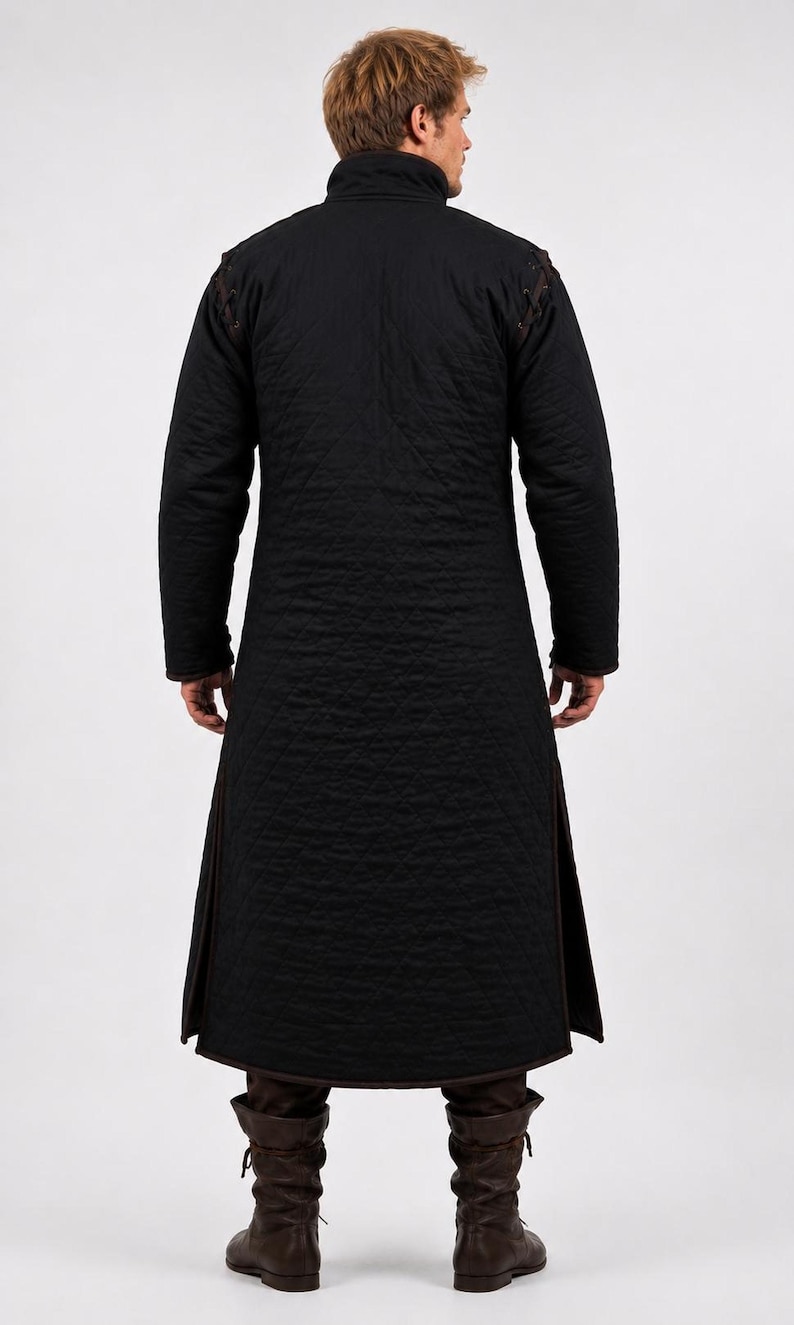 The back view of a man wearing a black quilted long gambeson coat and brown boots.