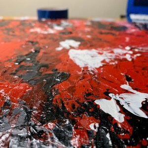 K&ouml;nnte beinhalten: Abstraktes Gem&auml;lde mit dicken Schichten roter, schwarzer und wei&szlig;er Farbe. Die Farbe ist in einem strukturierten Impasto-Stil aufgetragen.