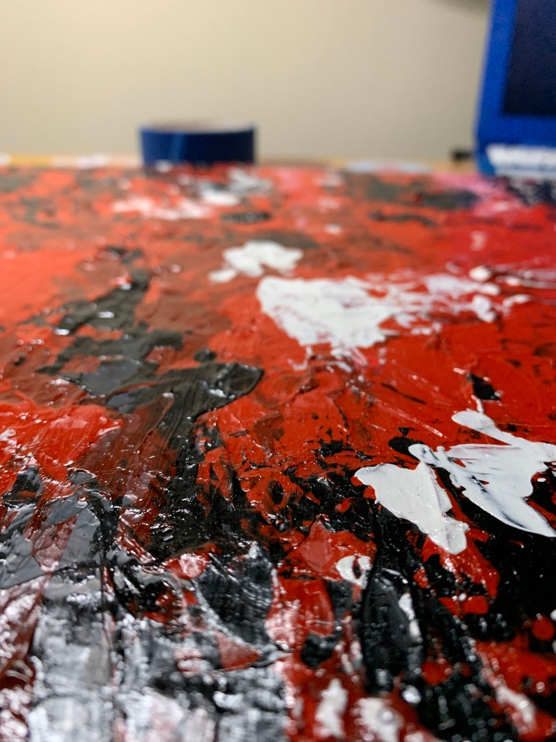K&ouml;nnte beinhalten: Abstraktes Gem&auml;lde mit dicken Schichten roter, schwarzer und wei&szlig;er Farbe. Die Farbe ist in einem strukturierten Impasto-Stil aufgetragen.