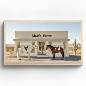 May include: A white horse and a brown horse, both saddled, stand in front of a building with the sign "Marfa Store" above the entrance. The horses are facing each other, and the building is set against a desert landscape.