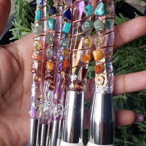 May include: Set of six makeup brushes with clear handles embedded with colourful gemstones and wrapped in copper wire. The brushes have silver metal ferrules and white bristles.