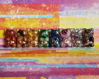 May include: A row of eight colorful, crystal-filled, resin bear figurines. Each bear is a different color, including red, orange, yellow, green, blue, purple, pink, and white.