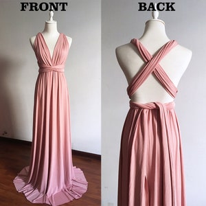 Pode incluir: Um vestido maxi rosa p&oacute;  com um corpete estilo envelope e costas cruzadas. O vestido &eacute; feito de um tecido macio e el&aacute;stico e tem uma silhueta fluida.