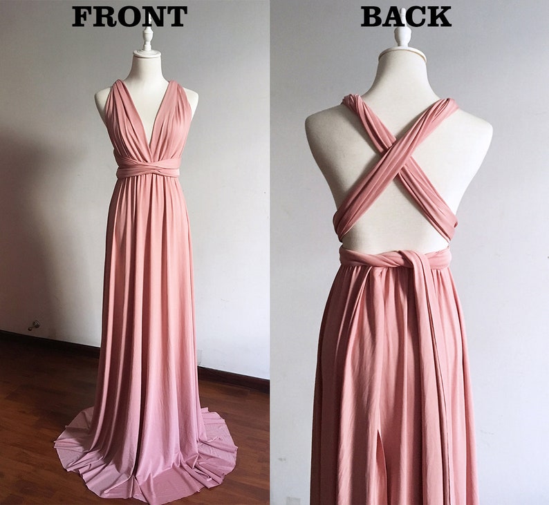 Pode incluir: Um vestido maxi rosa p&oacute;  com um corpete estilo envelope e costas cruzadas. O vestido &eacute; feito de um tecido macio e el&aacute;stico e tem uma silhueta fluida.