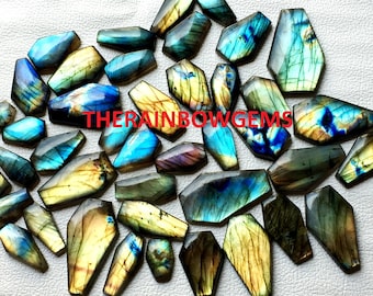 May include: A collection of 20 labradorite gemstone cabochons in various shades of blue, green, and gold. The stones are all cut in a teardrop shape and have a high polish.
