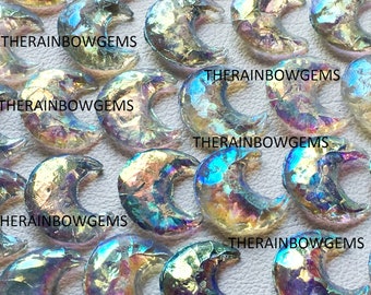 Op de afbeelding: Een groep van iriserende glazen halve maanvormen. Het glas is helder met een regenboogkleurige glans. De tekst "THERAINBOWGEMS" verschijnt meerdere keren in de afbeelding.