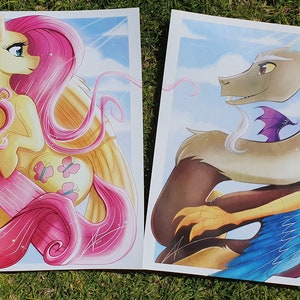 May include: Two illustrations of characters from the My Little Pony franchise. The first illustration is of Pinkie Pie, a pink pony with a yellow body and a pink mane and tail. The second illustration is of Discord, a dragon with a light brown body, a white mane, and blue wings.