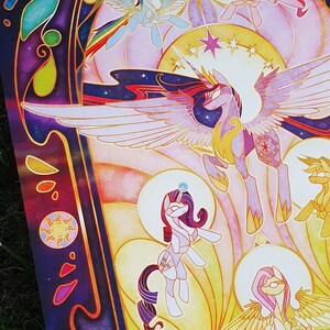 May include: A colorful stained glass style illustration of the main characters from the animated series My Little Pony: Friendship is Magic. The characters are depicted in a circular frame with a starburst design. The illustration is set against a dark purple background with stars and other celestial elements. The text "The Cold Creature" is visible in the lower right corner.