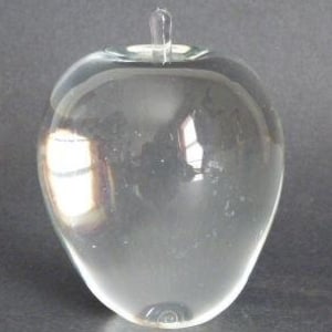 May include: A clear glass apple sculpture. The apple is smooth and has a rounded shape.