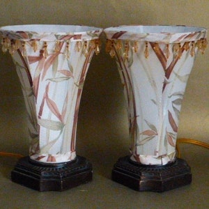 May include: Two matching table lamps with white and brown patterned shades. The shades have a beaded fringe trim. The lamps have dark brown bases.
