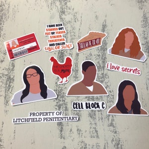 May include: A set of nine stickers featuring characters and quotes from the TV show "Orange is the New Black". The stickers are printed on white paper with black outlines and feature a variety of colors, including red, orange, yellow, green, blue, and purple. The stickers include images of Piper Chapman, Taystee Jefferson, Poussey Washington, Suzanne "Crazy Eyes" Warren, and Gloria Mendoza. The stickers also include quotes from the show, such as "I have been starved out. Felt up. Teased. Stalked. Threatened. And called Taylor Swift", "The chicken is a myth", "I threw an pie for you", "Cell Block C", "i love secrets", and "Property of Litchfield Penitentiary".