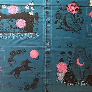 Op de afbeelding: Teal stof met een herhalend patroon van zwarte en roze illustraties. De illustraties omvatten een naaimachine, een vogel, een eenhoorn, een beer, een maan, bloemen en sterren. De stof heeft een wit stippenpatroon.