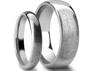 Puede incluir: Dos alianzas de boda plateadas con un diseño de huella digital. Las alianzas están hechas de carburo de tungsteno y tienen un acabado pulido.