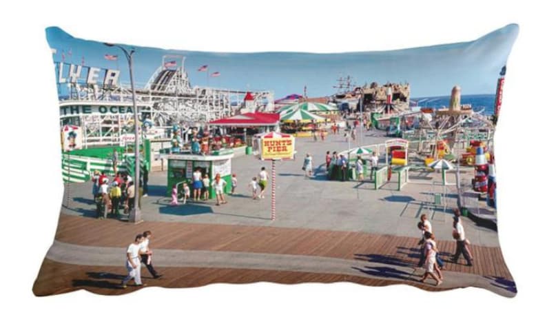 May include: A vintage photograph of a crowded amusement park on a boardwalk. The photo shows a roller coaster, a Ferris wheel, and other rides. There are people walking around and enjoying the day. The text "Hunt's Pier" is visible on a sign.