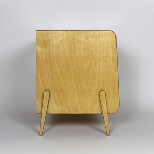 May include: A light wood cabinet with a rounded edge and four legs. The cabinet is made of plywood and has a natural wood finish.