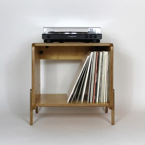 May include: A wooden record player stand with a turntable on top and a shelf below for storing vinyl records.