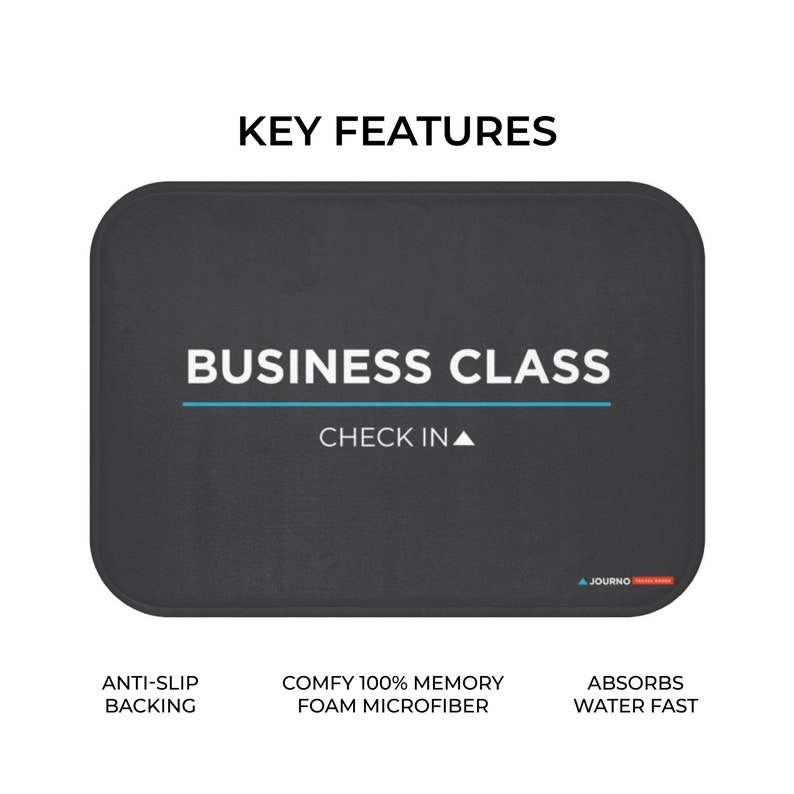 K&ouml;nnte beinhalten: Eine schwarze Badematte mit dem Text "BUSINESS CLASS CHECK IN" in Wei&szlig;. Die Matte hat einen blauen Streifen und den Text "ANTI-SLIP BACKING", "COMFY 100% MEMORY FOAM MICROFIBER" und "ABSORBS WATER FAST" in Wei&szlig;.
