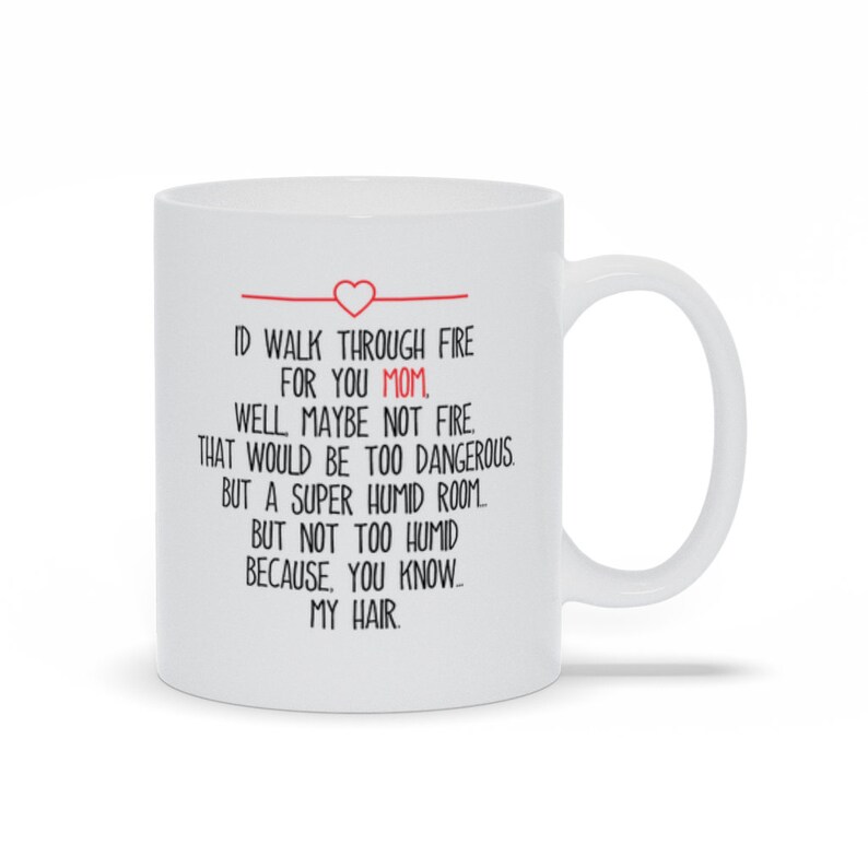 May include: White ceramic coffee mug with a red heart and the text "ID WALK THROUGH FIRE FOR YOU MOM, WELL MAYBE NOT FIRE. THAT WOULD BE TOO DANGEROUS BUT A SUPER HUMID ROOM BUT NOT TOO HUMID BECAUSE, YOU KNOW - MY HAIR."