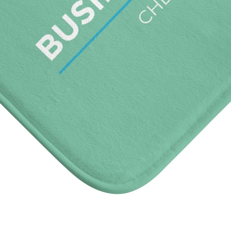 K&ouml;nnte beinhalten: Eine hellgr&uuml;ne Badematte mit dem Text "BUSINESS CHEF" in wei&szlig;en Buchstaben.