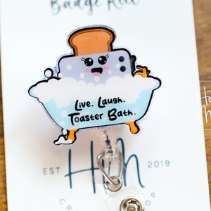 May include: A blue and white cartoon toaster in a bathtub with bubbles. The toaster has a smiling face and is holding a bar of soap. The text "Live. Laugh. Toaster Bath." is printed below the toaster.