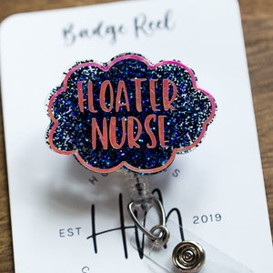 May include: A badge reel with a cloud-shaped design that reads "FLOATER NURSE" in pink lettering. The cloud is outlined in pink and filled with blue glitter. The reel is attached to a white card with the text "Badge Reel" and "Hot Mess Creative Shop".