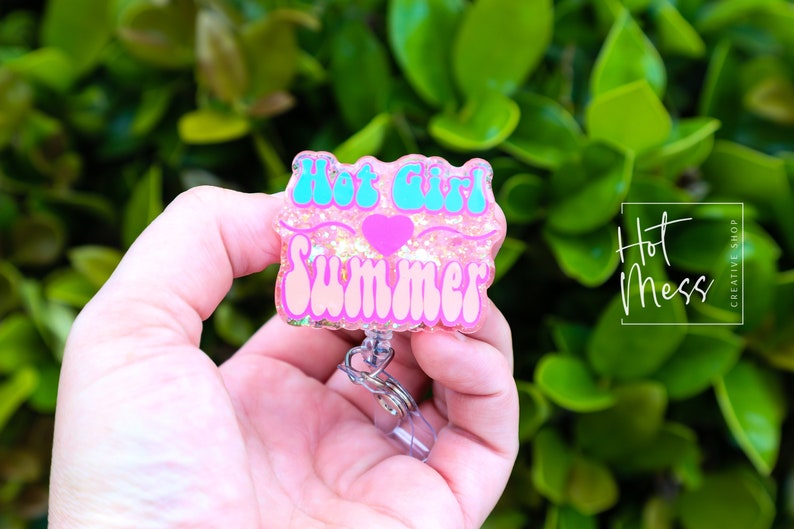 Pode incluir: Porta-crach&aacute; de glitter rosa com um design turquesa "Hot Girl Summer" e um cora&ccedil;&atilde;o rosa.