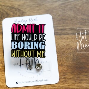 May include: White badge reel with black text that reads "Badge Reel Admit It Life Would Be Boring Without Me" with a silver retractable badge holder. The text is in pink, blue, and yellow. The badge reel is from the company "Hot Mess Creative Shop" and has the text "Est 2019" and "Creative Shop" on the bottom.