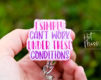 May include: Pink and purple glitter badge holder with the text "I simply can't work under these conditions".