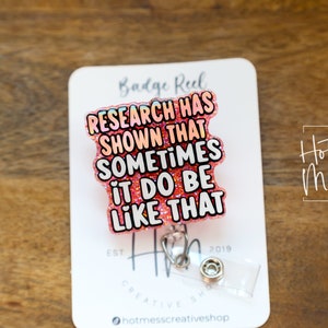 Op de afbeelding: Roze glitter badge reel met de tekst "RESEARCH HAS SHOWN THAT SOMETIMES IT DO BE LIKE THAT".
