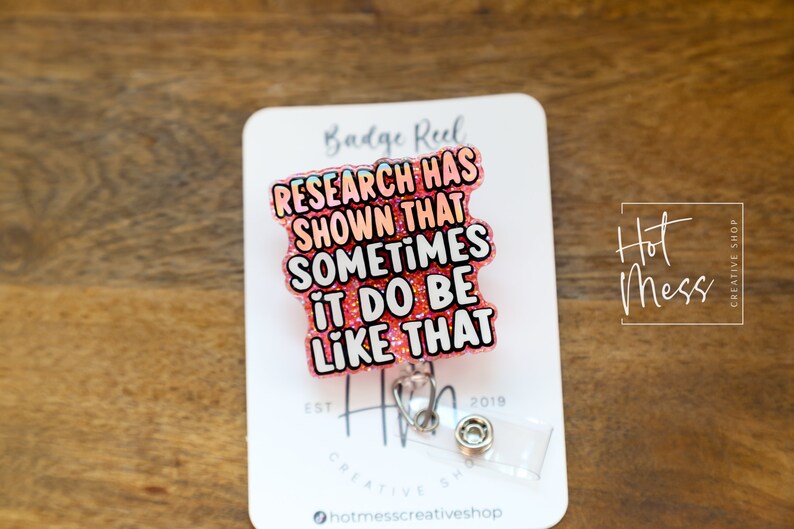 Op de afbeelding: Roze glitter badge reel met de tekst "RESEARCH HAS SHOWN THAT SOMETIMES IT DO BE LIKE THAT".