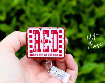 以下が含まれることがあります： 「RED」の文字と「Remember Everyone Deployed Until They All Come Home」の文字が入った、赤と白のグリッターバッジリール。 バッジリールには、透明なプラスチック製の格納式クリップが付いています。
