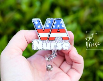 May include: A silver glitter badge holder with a red, white, and blue American flag design and the text "VA Nurse".