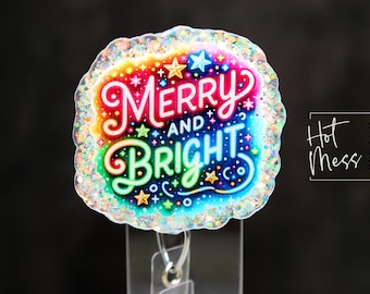 May include: A colorful badge reel with the words "Merry and Bright" in a rainbow design. The badge has a glittery border and star accents. The words are in a whimsical font. The background is black.
