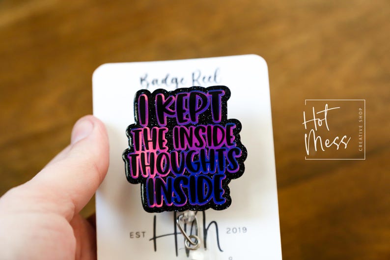 May include: A black and purple glitter badge reel with the text "I kept the inside thoughts inside".