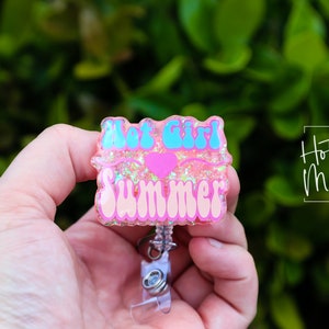 Pode incluir: Chaveiro de resina rosa com glitter com o texto "Hot Girl Summer" em letras azuis e rosas com um cora&ccedil;&atilde;o rosa no meio.