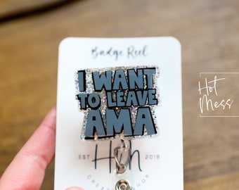 May include: A silver glitter badge reel with a black and silver glitter charm that says "I WANT TO LEAVE AMA".