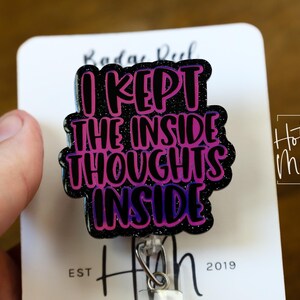 May include: A black and purple glitter badge reel with the text "I kept the inside thoughts inside".