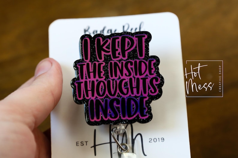 May include: A black and purple glitter badge reel with the text "I kept the inside thoughts inside".